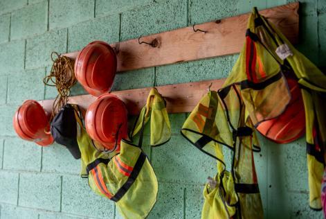 work hardhats and high visibility vesta hangin on a hanger