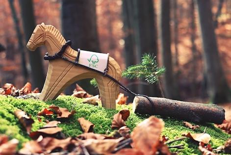 A toy horse with an FSC logo, towing a log